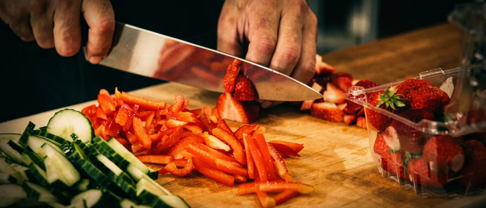 Chef T slicing fresh peppers on a wooden board