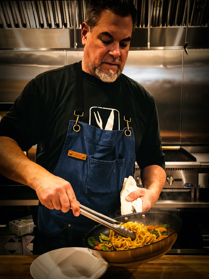 Chef T plating a fresh dish straight from the pan