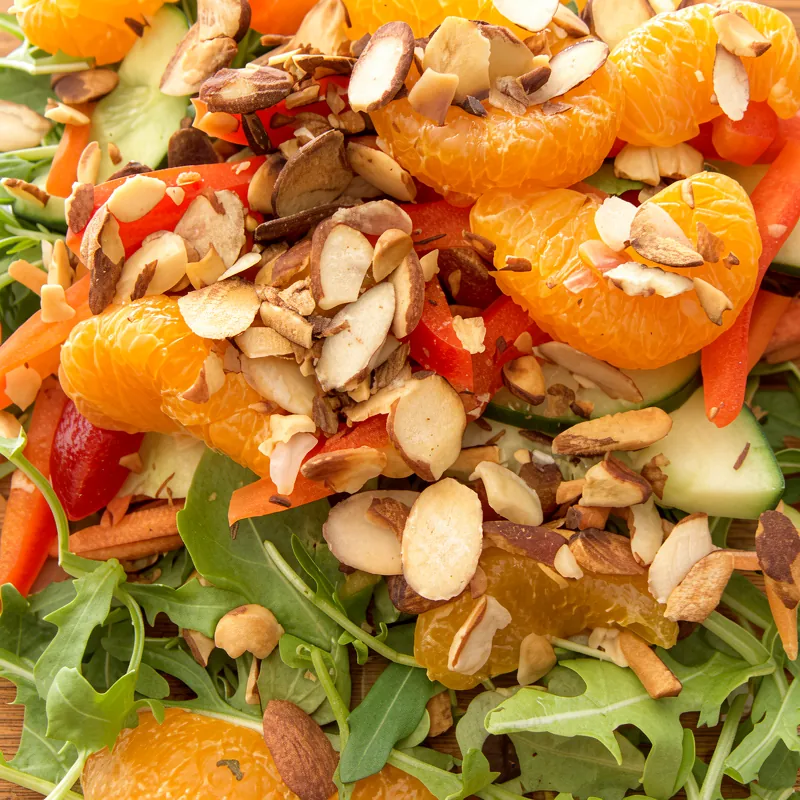 A chef-crafted salad with arugula, mandarin, toasted almonds and red pepper