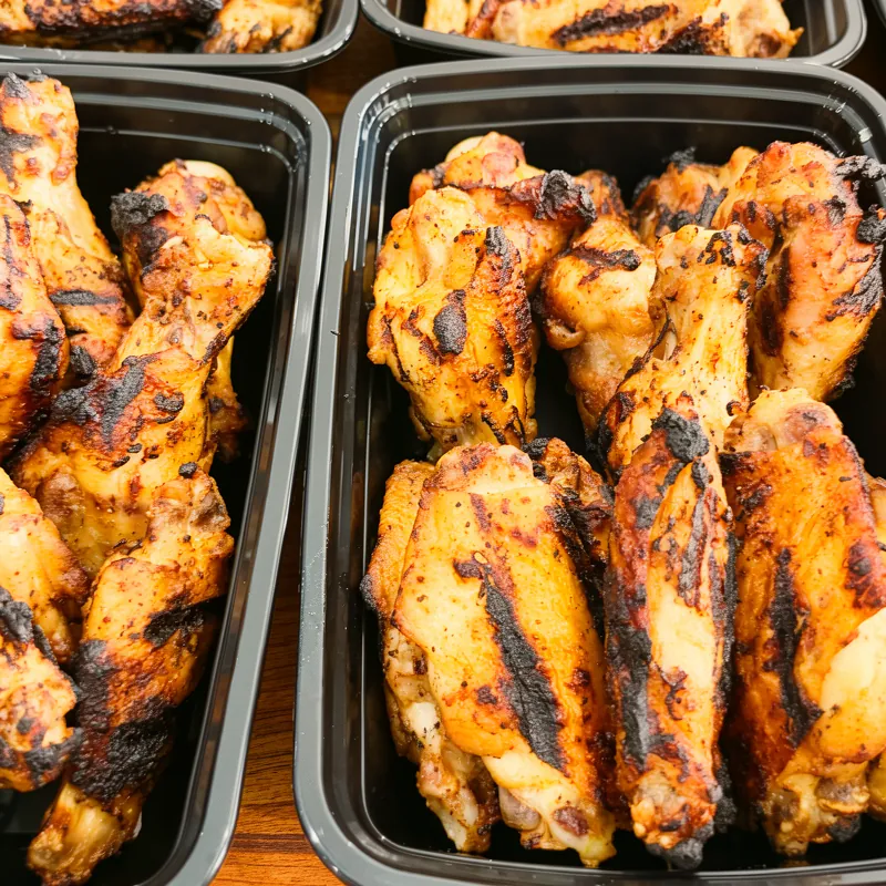Char-grilled chicken wings portioned into meal-prep trays